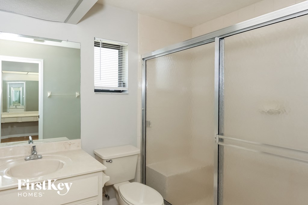 a bathroom with a shower and a sink and a toilet