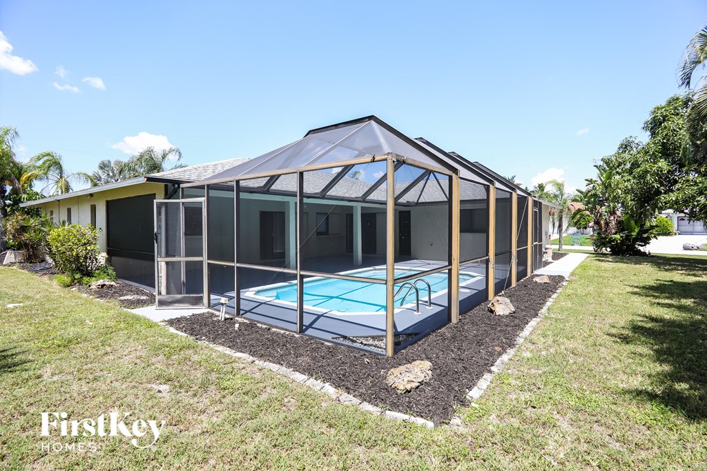 a house with a pool and a screened in porch
