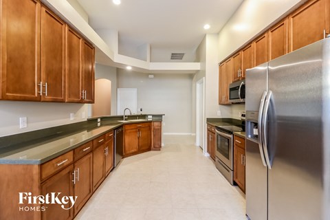 A kitchen with wooden cabinets and a stainless steel refrigerator.
