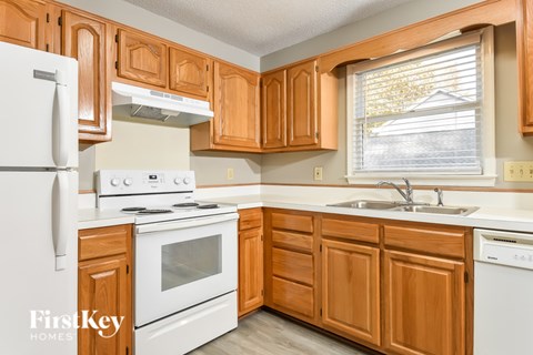A kitchen with wooden cabinets and white appliances.