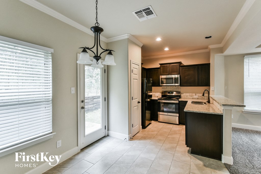 A kitchen with a black island and stainless steel appliances.