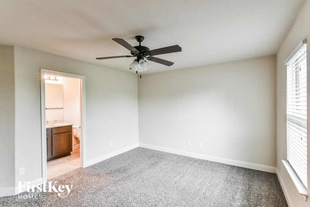 A room with a ceiling fan and a carpeted floor.