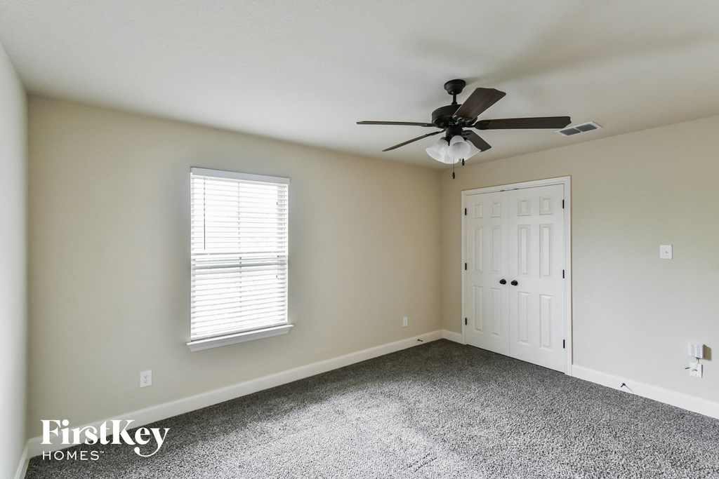 A room with a ceiling fan and a door.