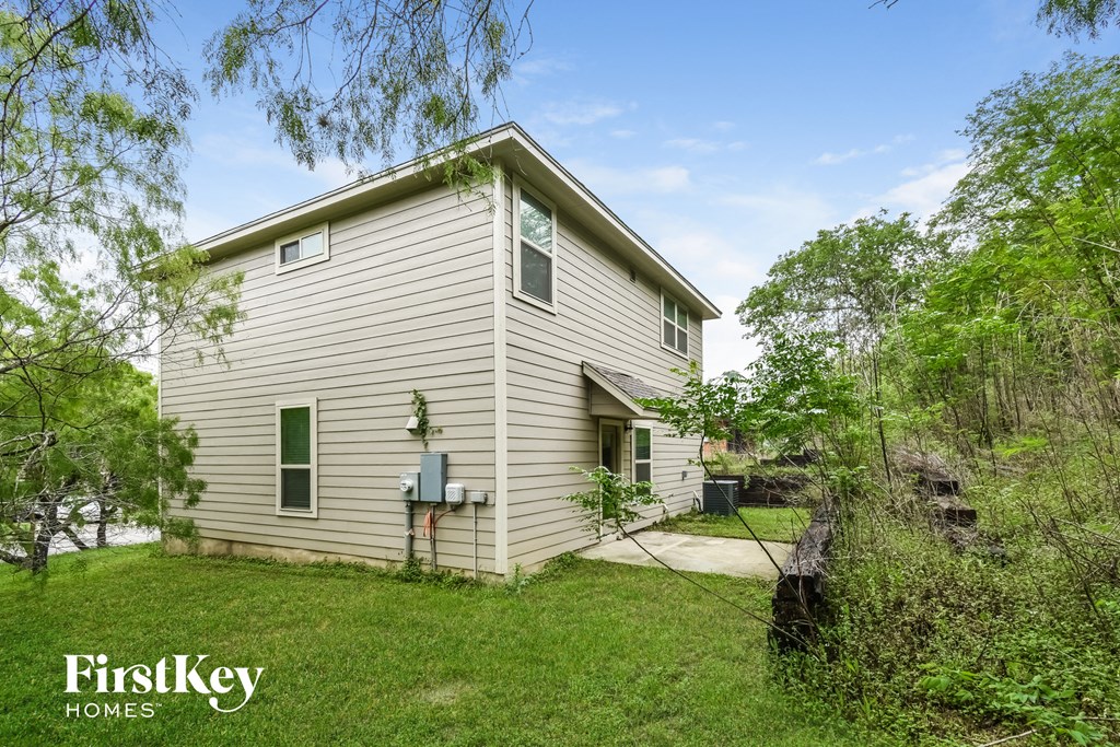 A house with a green lawn and trees in the background.