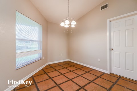 the living room of a home with a large window and a checkered floor
