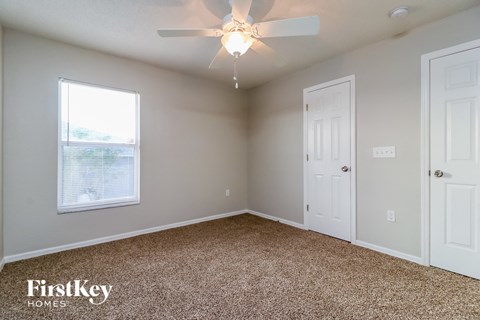 a bedroom with a ceiling fan and a white door