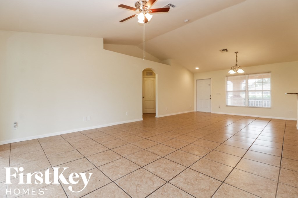 A spacious room with a ceiling fan and tiled flooring.