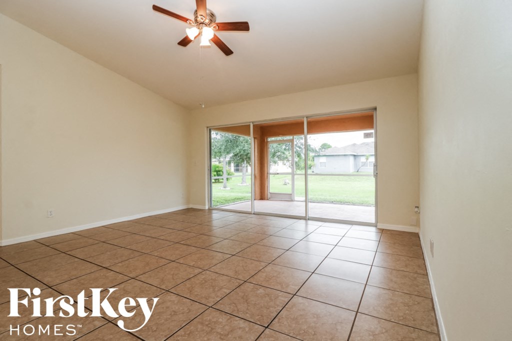 A room with a ceiling fan and tiled floor.
