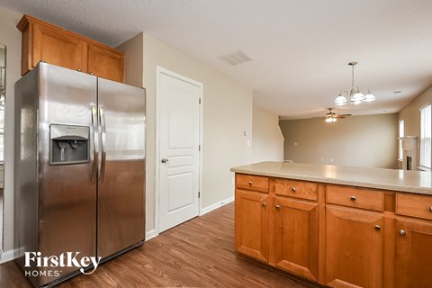 A kitchen with wooden cabinets and a stainless steel refrigerator.