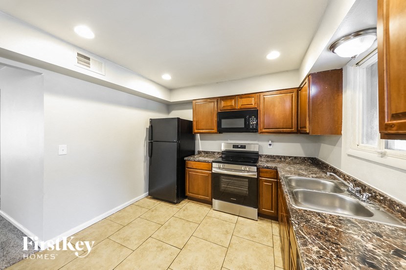 a kitchen with granite counter tops and wooden cabinets