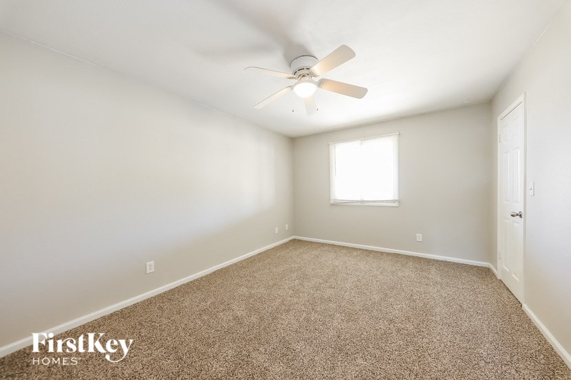 a empty room with a ceiling fan and a window