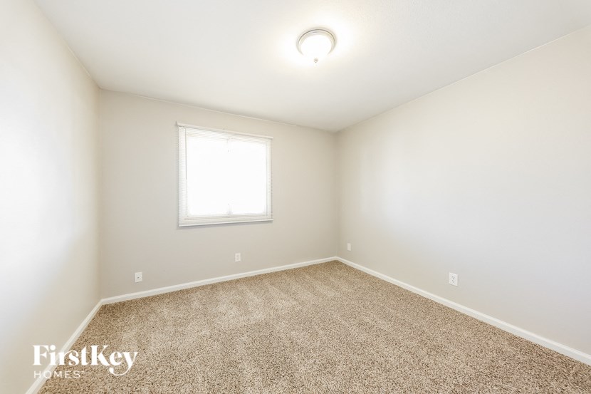 an empty room with carpet and a window