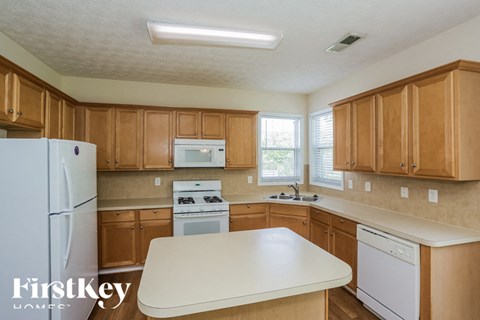 A kitchen with wooden cabinets and a white fridge.