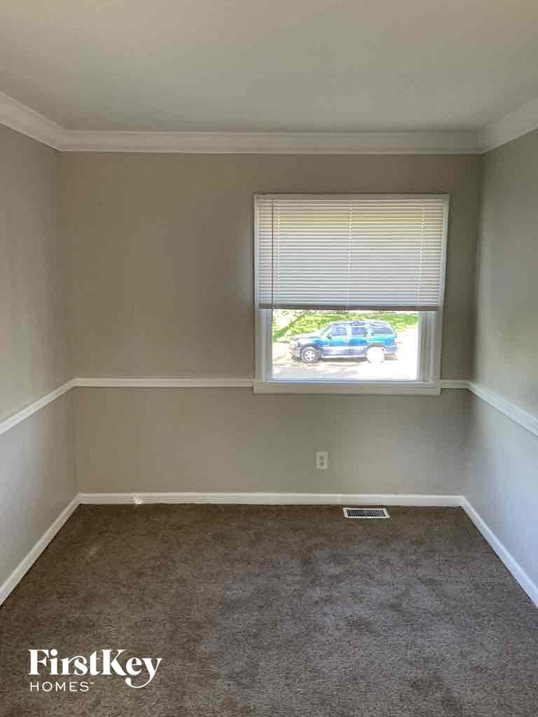 an empty room with a window and a carpet