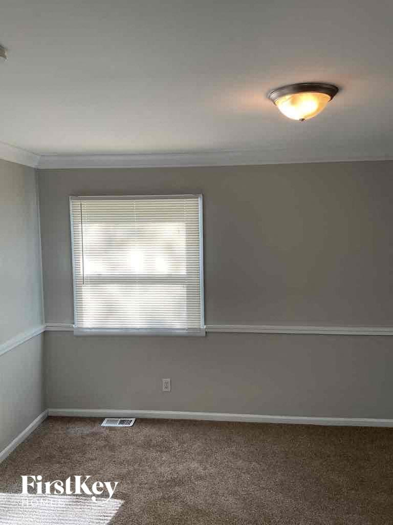 an empty room with a window and a light on the ceiling