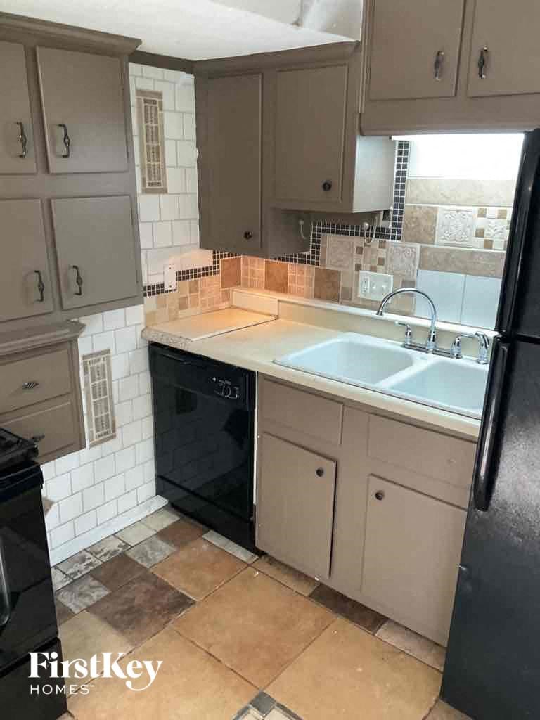 a kitchen with a sink and a black dishwasher