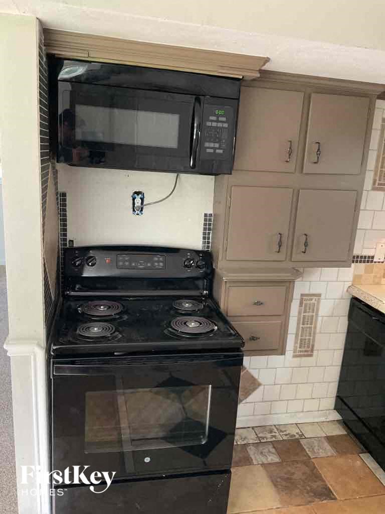 a kitchen with a stove and a microwave on top of it