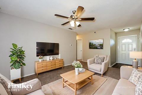 A living room with a wooden coffee table and a beige sofa.