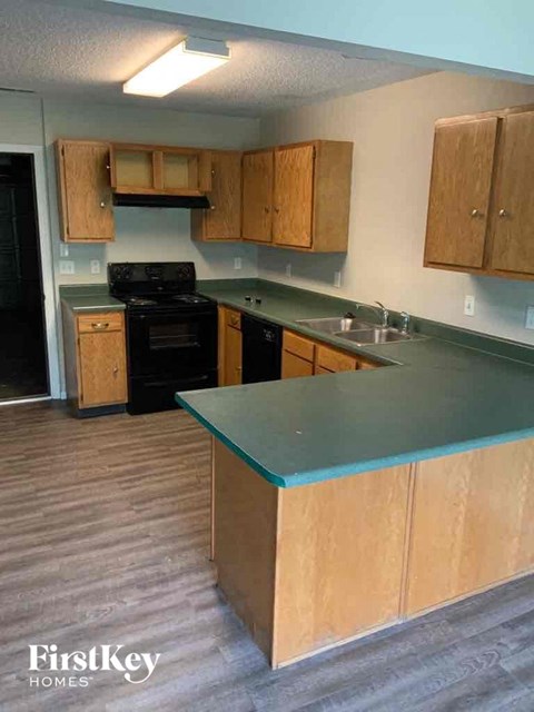 A kitchen with wooden cabinets and a black stove top oven.