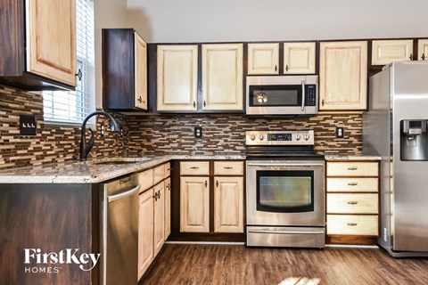 a kitchen with wooden cabinets and stainless steel appliances