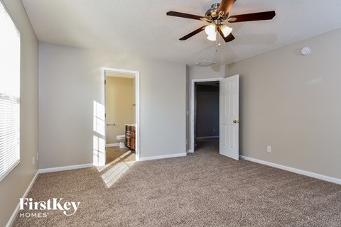 a living room with carpet and a ceiling fan