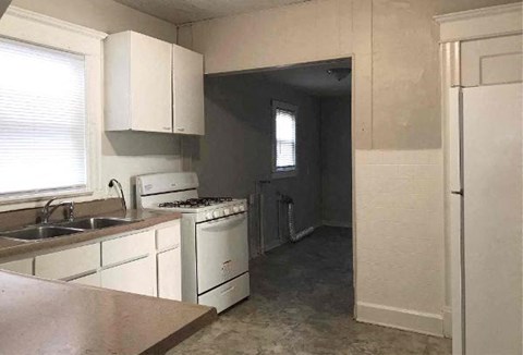 A kitchen with white cabinets and appliances.