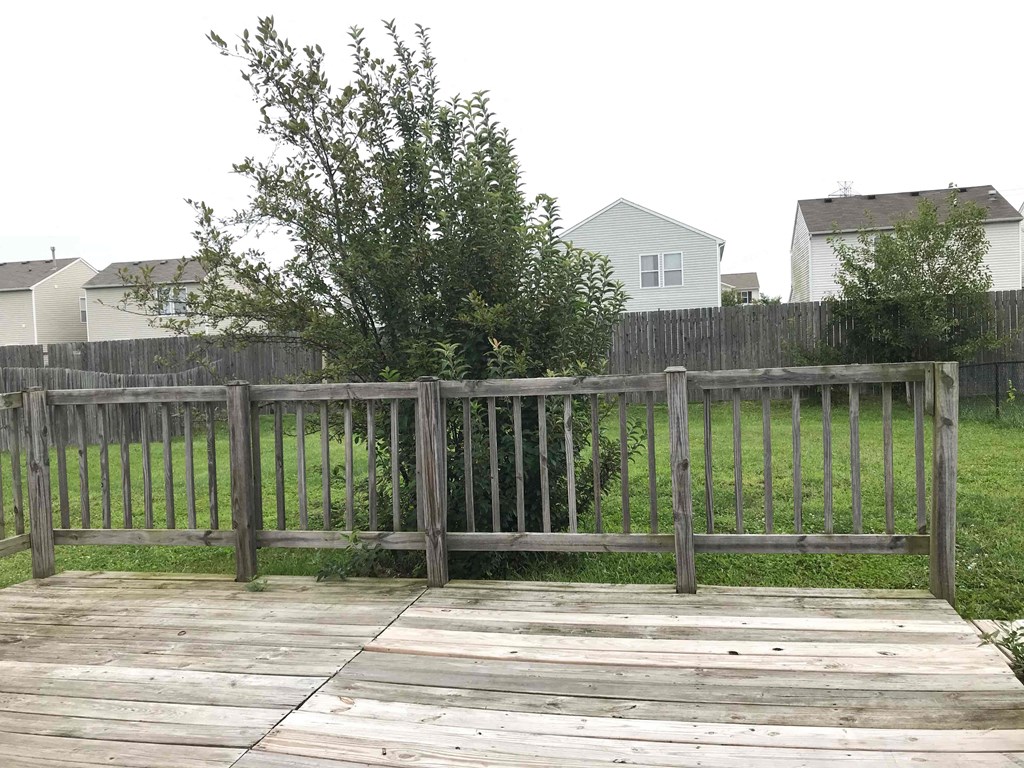 a backyard with a wooden deck and a wooden fence