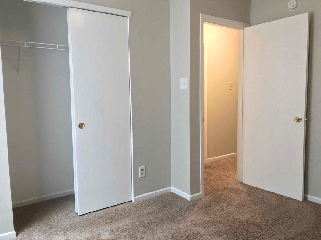 a bedroom with a closet and a door open to a hallway