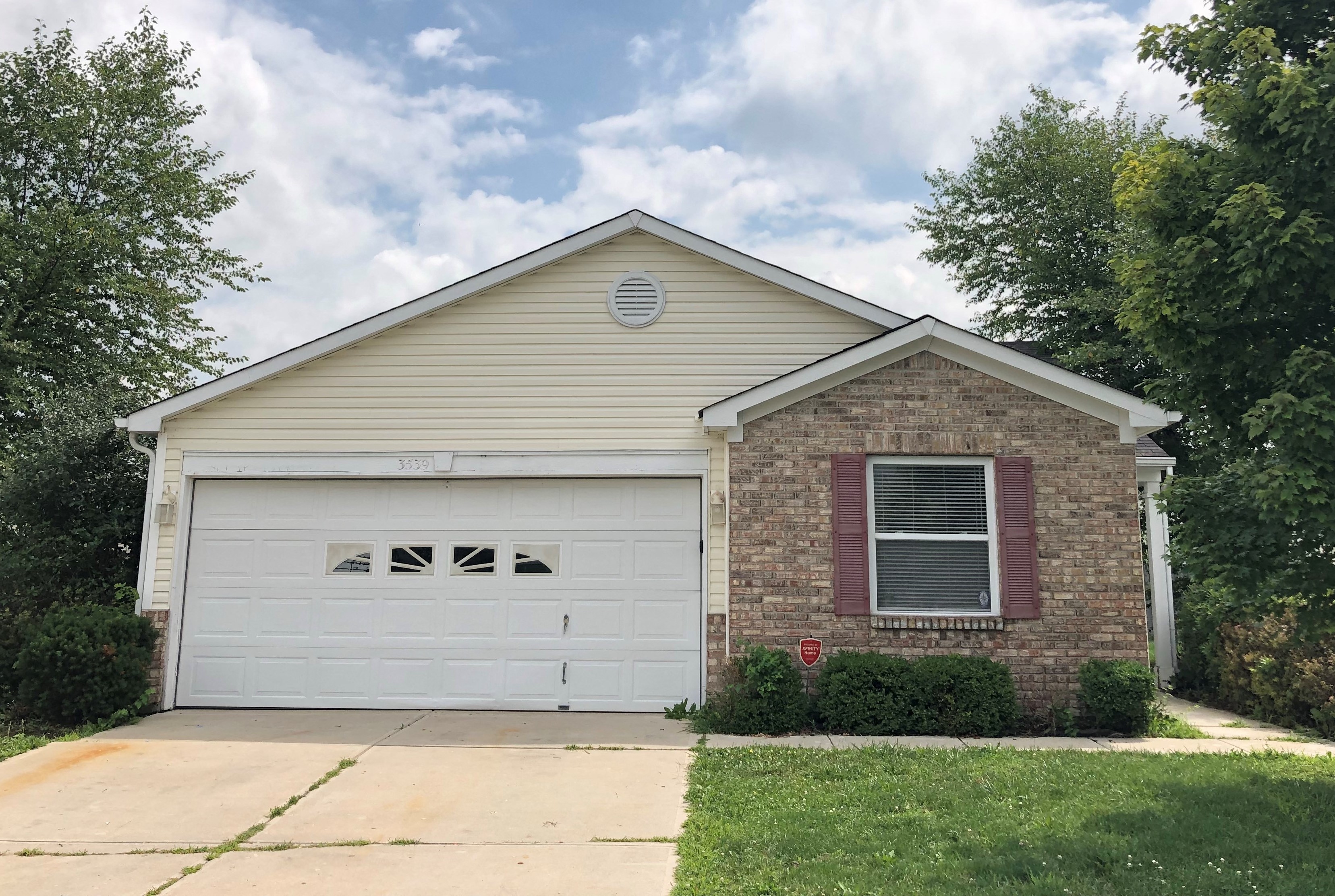 a home with a white garage door and a brick house