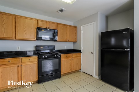 A kitchen with wooden cabinets and black appliances.