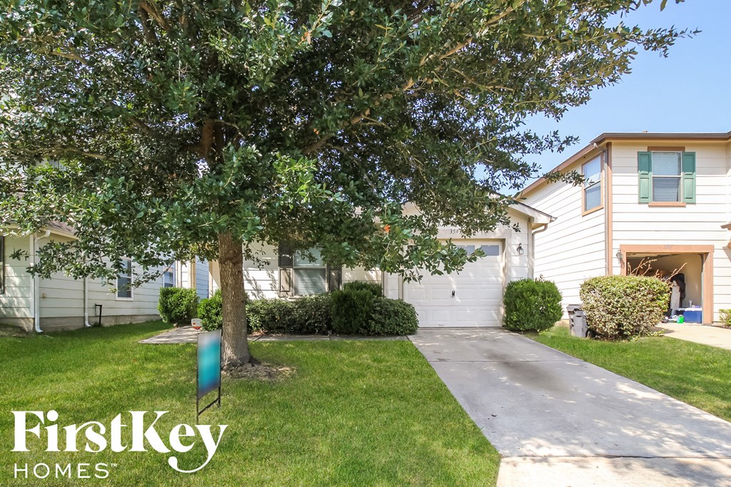 A tree in front of a house with a sign that says FirstKey Homes.