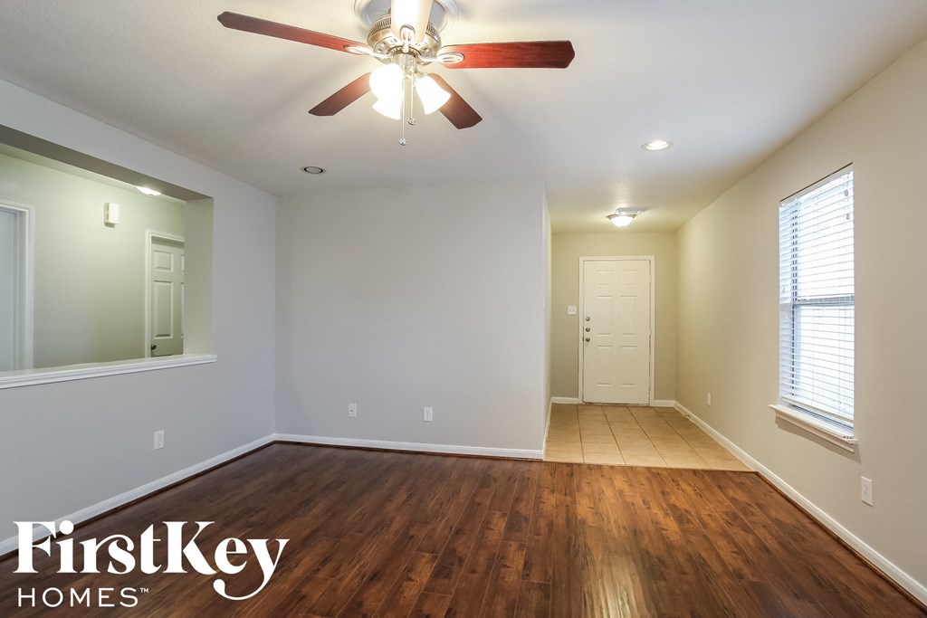 A room with a wooden floor and a ceiling fan.