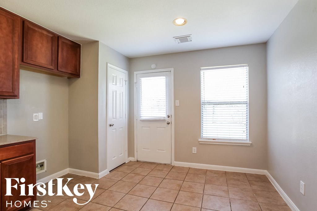 A room with a white door and a window with blinds.