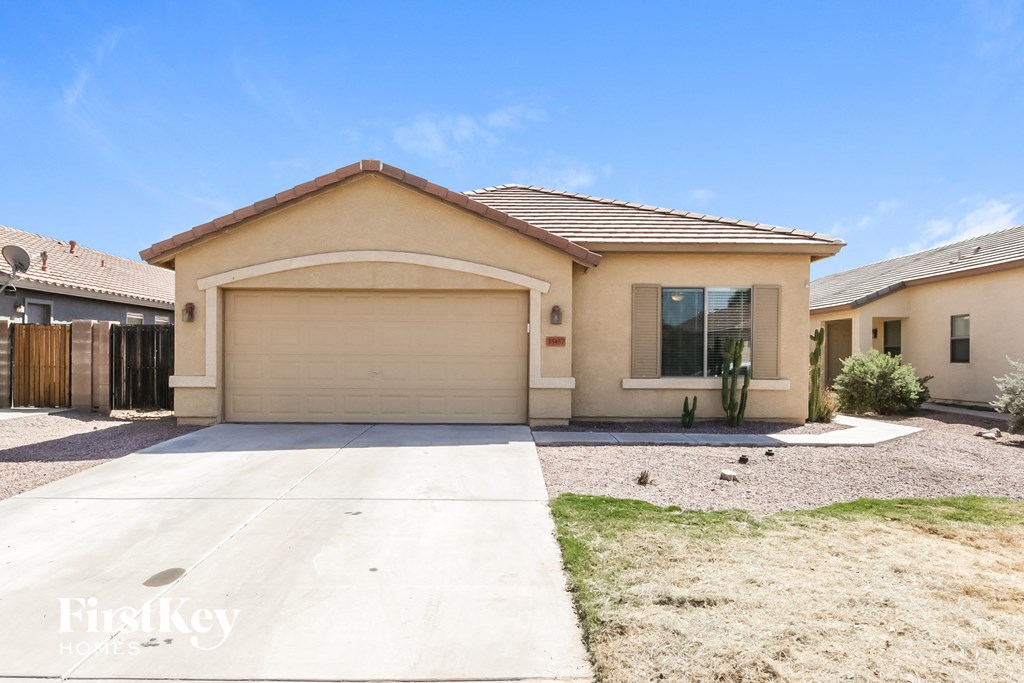 a beige house with a driveway and a garage door