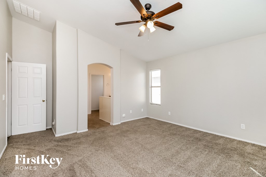 a living room with carpet and a ceiling fan