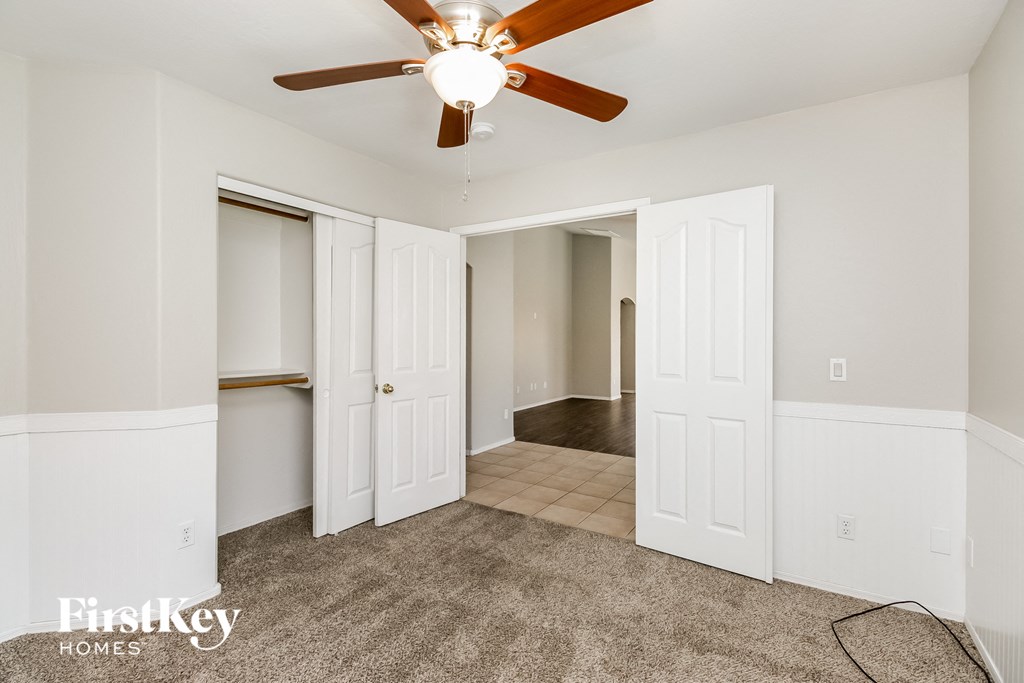 a bedroom with two closets and a ceiling fan