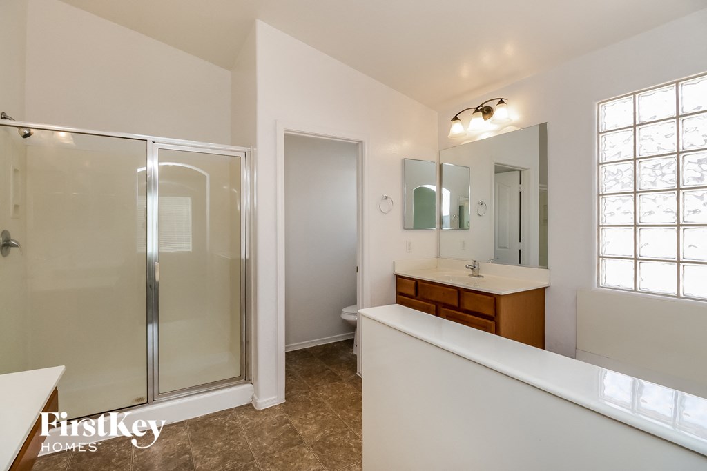a bathroom with a shower and a sink and a mirror