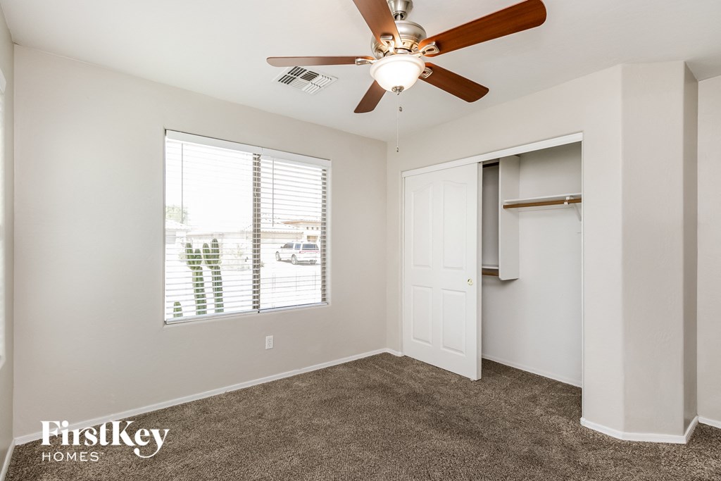 a bedroom with a ceiling fan and a closet