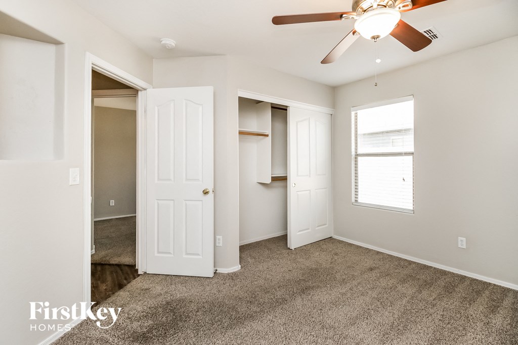 a bedroom with a closet and a ceiling fan