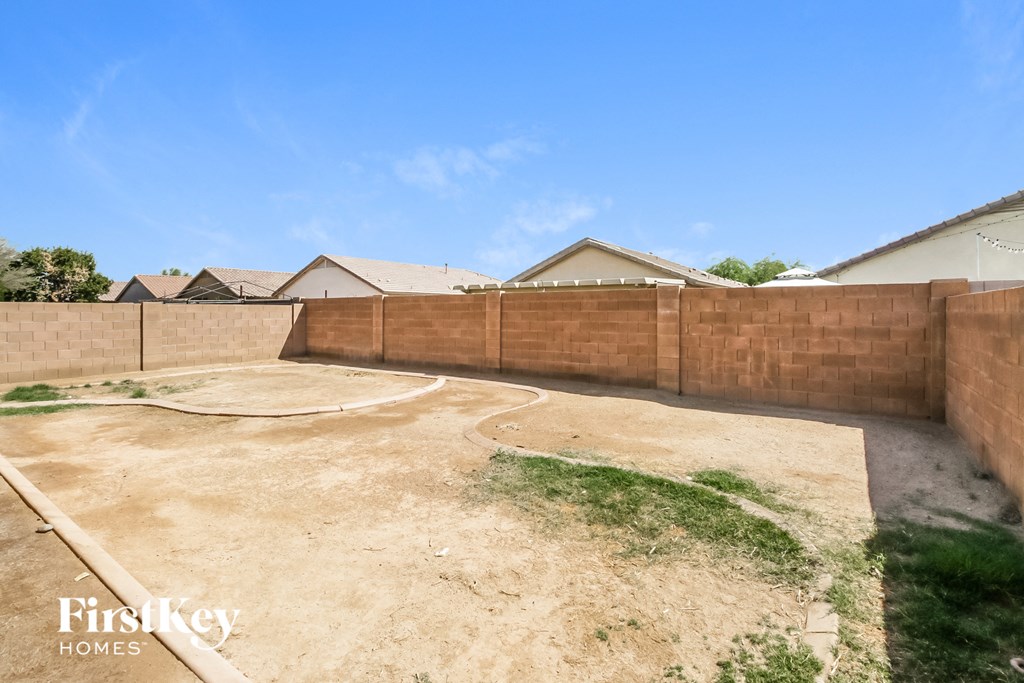 a backyard with a retaining wall and a fence