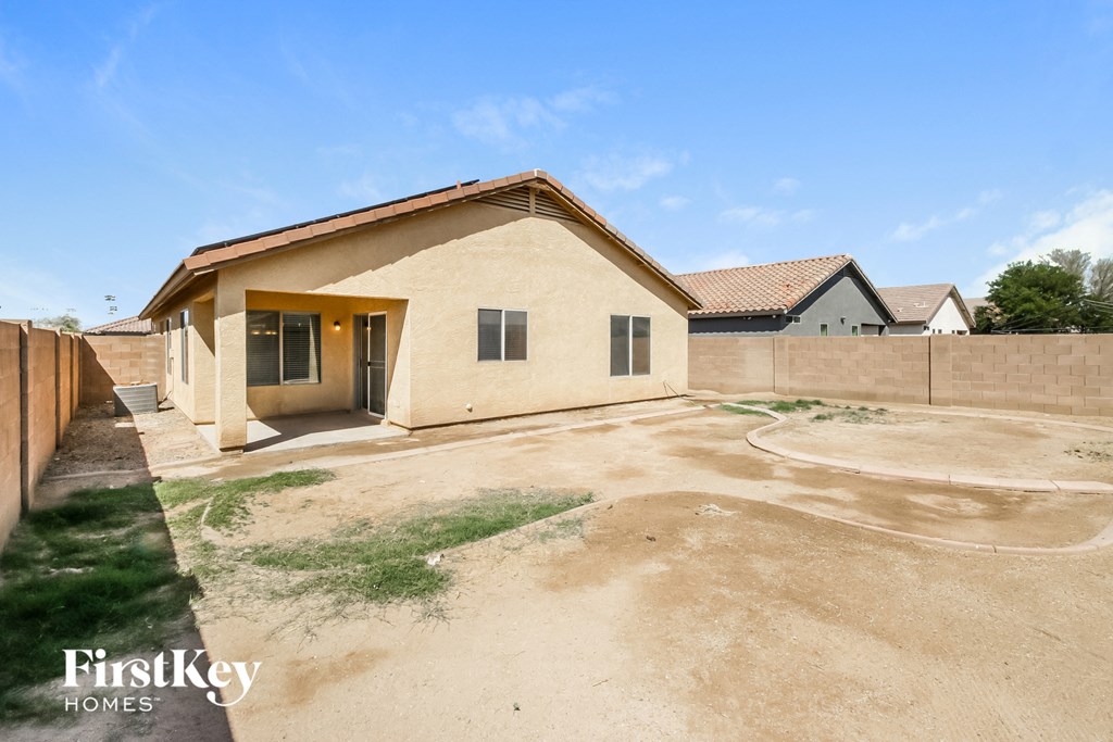 a home with a dirt driveway and a brick house