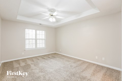 a bedroom with carpet and a ceiling fan