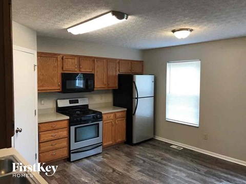 A kitchen with wooden cabinets and a stainless steel refrigerator.