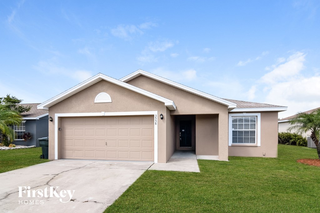 a beige house with a driveway and a garage door