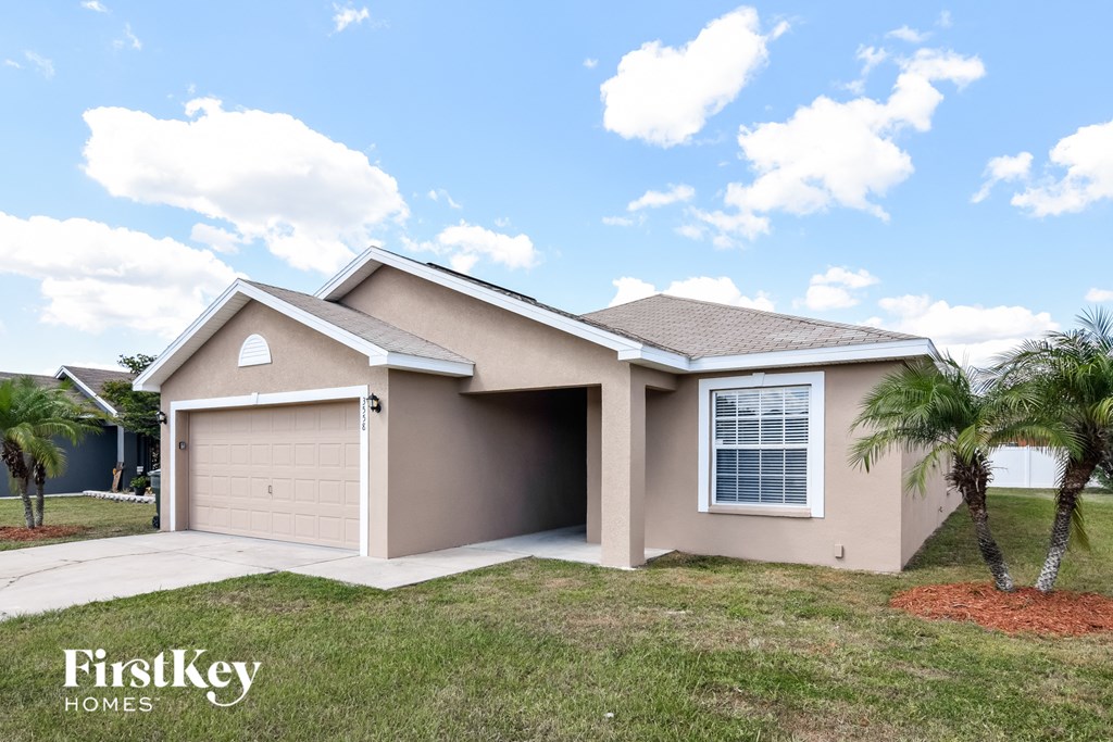 a beige house with a garage and palm trees