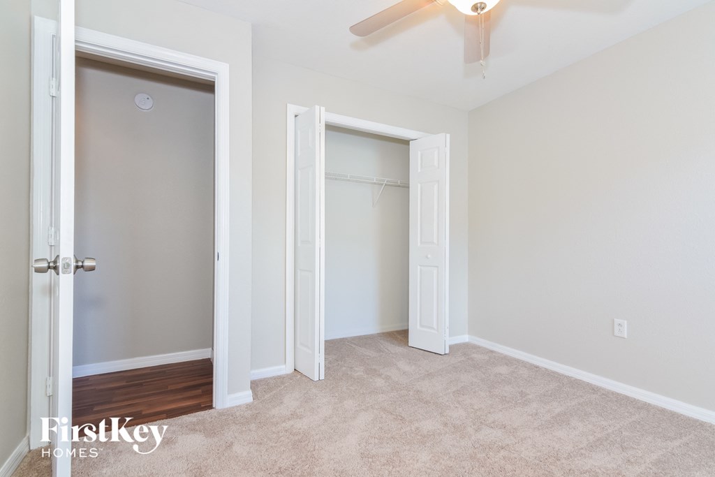 a bedroom with a closet and a ceiling fan