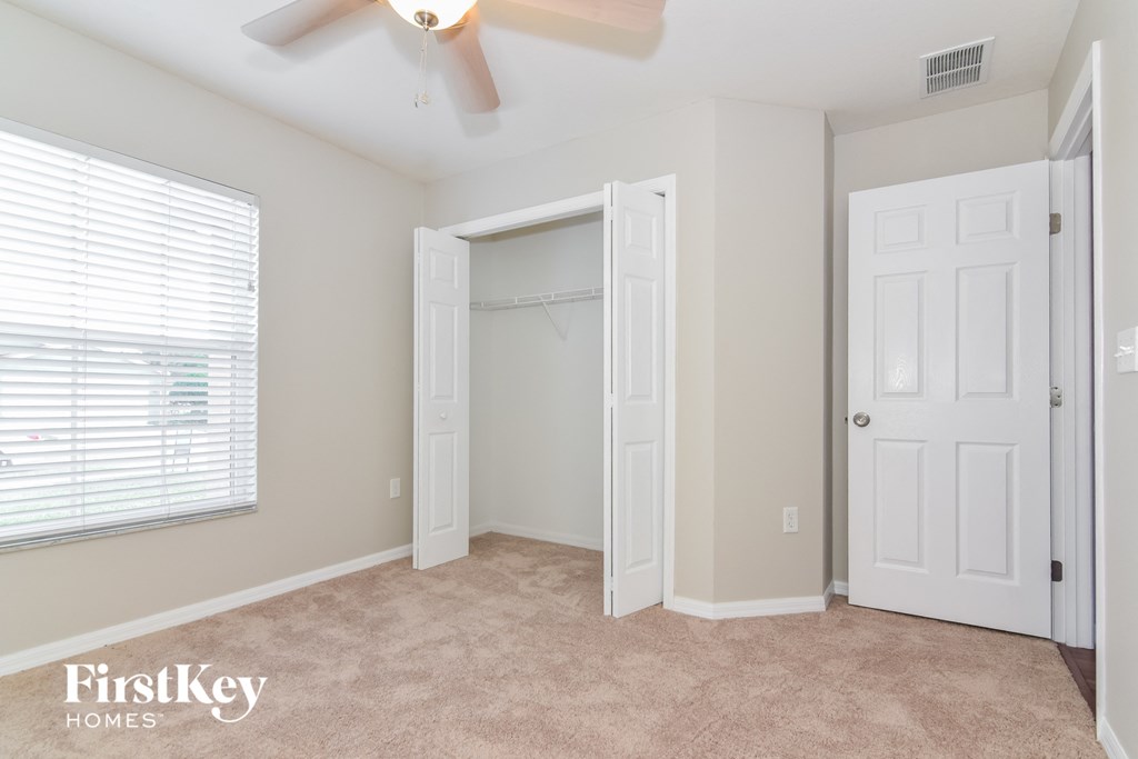 a bedroom with a closet and a ceiling fan