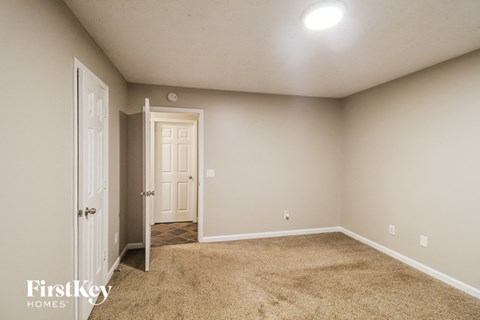 a bedroom with a door and a carpeted floor