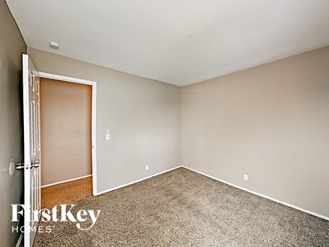 a bedroom with carpet and a door to a closet