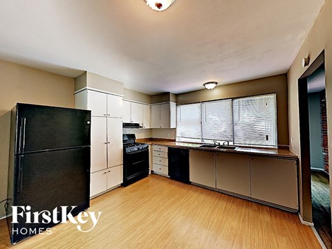 a kitchen with black appliances and a wood floor